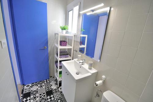 La salle de bains est pourvue d'un lavabo blanc et d'une porte bleue. dans l'établissement ATALAYAS 153, à Peñíscola