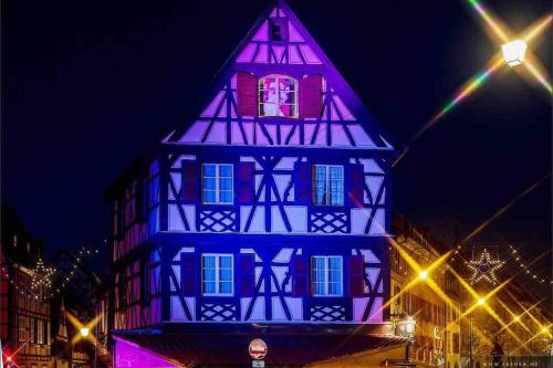 a building is lit up in blue and purple at Coeur Alsace in Colmar