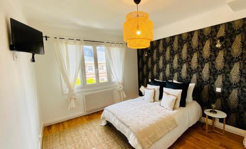 sypialnia z białym łóżkiem i telewizorem w obiekcie EL PARADISE - Coeur de Ville et Basilique au Balcon w mieście Lisieux