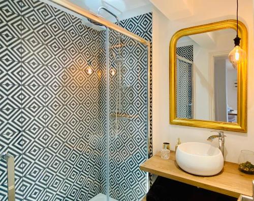 La salle de bains est pourvue d'un lavabo et d'une douche avec un miroir. dans l'établissement EL PARADISE - Coeur de Ville et Basilique au Balcon, à Lisieux