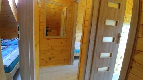 a door leading to a bedroom in a wooden cabin at Siedlisko Niechorze in Niechorze