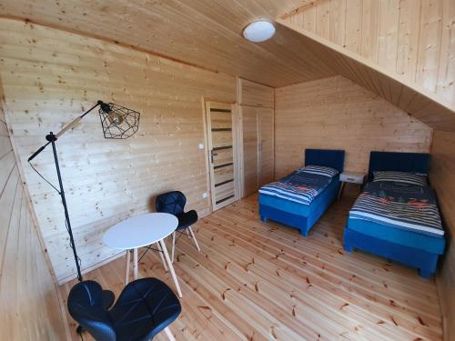 a room with two beds and a table in a cabin at Baltic Sea- domki z jacuzzi blisko natury in Władysławowo