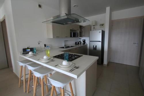 a kitchen with a island with bar stools and a refrigerator at Premier Apartment Downtown 4 Guests 1604 in Mexico City
