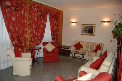 a living room with red and white furniture and curtains at Hotel I Pionieri in Abetone