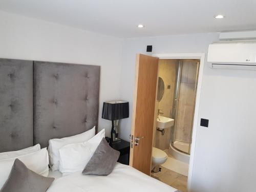 a bedroom with a bed and a bathroom with a toilet at Luxlogic in London