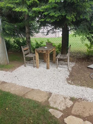a picnic table and two chairs and a table and bench at Belette Apartments & Park in Nikšić