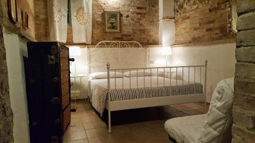 1 dormitorio con 1 cama y 1 silla en Casa Vacanze Fornace, en Buonconvento