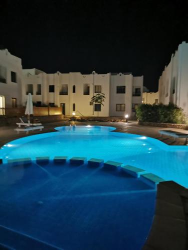 a large blue swimming pool at night at Chic Apartment 2 in Sharm El Sheikh
