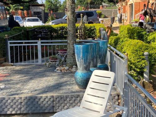a white chair sitting next to a blue vase at Lake Victoria Country Home in Entebbe