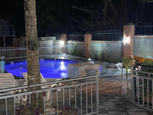a swimming pool in a yard at night at Lake Victoria Country Home in Entebbe