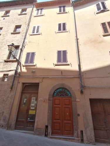 a building with two doors in a street at Camere la torre in Volterra