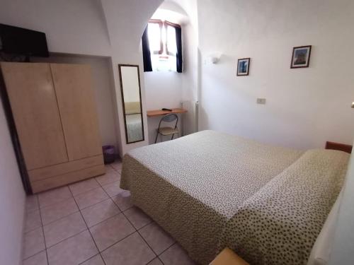 um quarto com uma cama, um espelho e uma porta em Camere la torre em Volterra