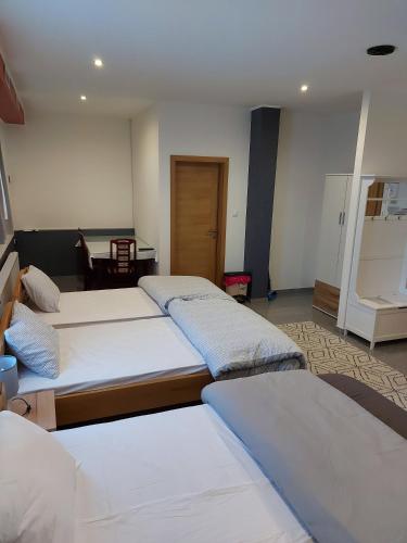 a bedroom with three beds and a table at SOBE RIM BREZJE DRAVSKO in Cestica