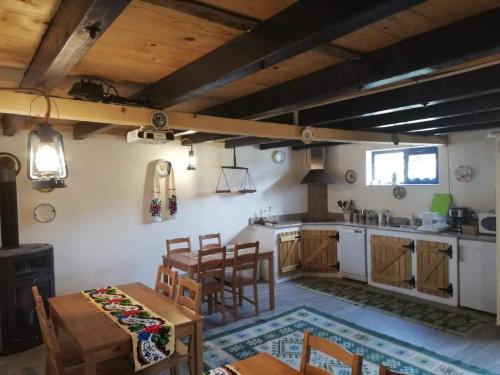 Una cocina y un comedor con mesa y sillas. en Pajisti Verzi / Green Meadows Guest House, en Vişeu de Sus