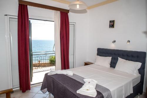 a bedroom with a bed with a view of the ocean at Empress Corfu in Perama