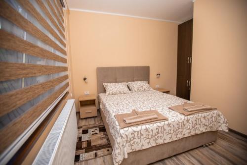 a small bedroom with a bed and a balcony at Vila Todorović in Bela Crkva