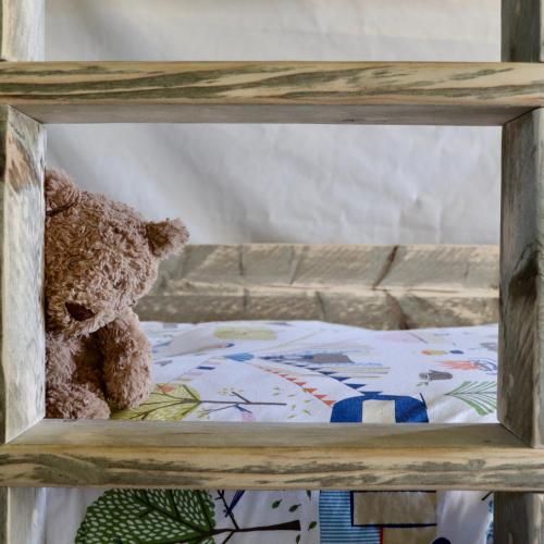 a teddy bear sitting on top of a bed at Brackenhill Glamping - Safari Tent with Hot Tub in Ivybridge