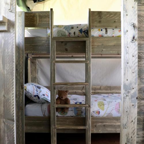 a wooden bunk bed with a teddy bear on it at Brackenhill Glamping - Safari Tent with Hot Tub in Ivybridge