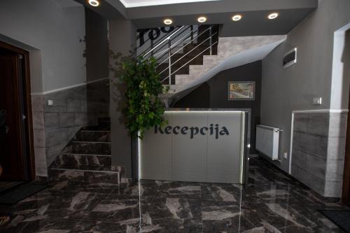 a lobby with a staircase with a sign that reads neederica at Vila Todorović in Bela Crkva