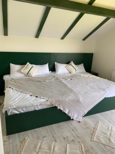 a bedroom with a bed with white sheets and pillows at Căsuța Top House in Zărneşti