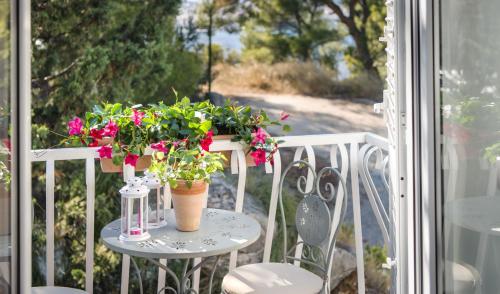 a table with flowers on top of a balcony at Lavica Seaside Apartments, Podstrana in Podstrana