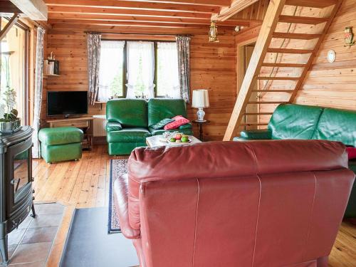een woonkamer met een rode bank en groene stoelen bij Alluring Holiday Home in Fraiture with Infrared Sauna in Fraiture