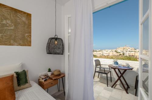 a bedroom with a bed and a table and a window at Anatoli Hotel in Naxos Chora