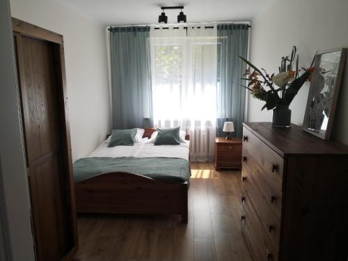 sypialnia z łóżkiem, oknem i komodą w obiekcie Apartament przy Starówce w mieście Sandomierz