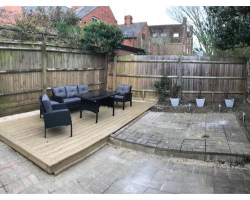 a patio with a table and chairs and a fence at Iffley Town House in Oxford