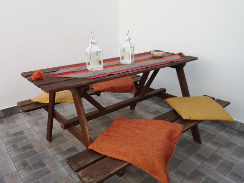 a wooden table with two chairs and two candles on it at Casa Vacanza Taviano in Taviano