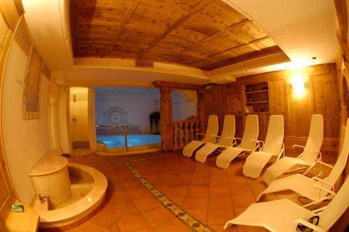 a room with a bunch of chairs in it at Hotel Meida in Pozza di Fassa