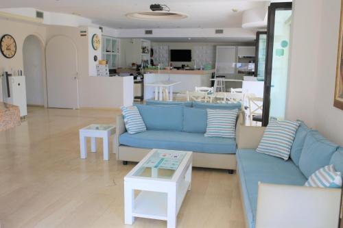 a living room with a blue couch and a table at Castro Hotel in Amoudara Herakliou