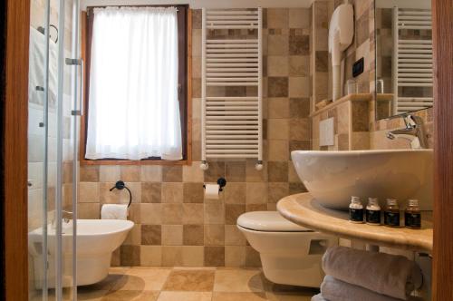 bagno con servizi igienici e lavandino di Hotel Castor a Champoluc
