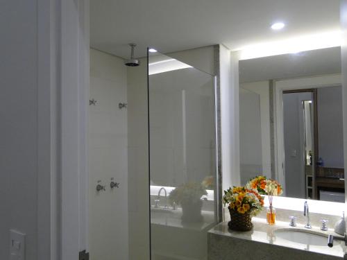 a bathroom with a mirror and a sink at Flat Itaipava - Granja Brasil in Itaipava