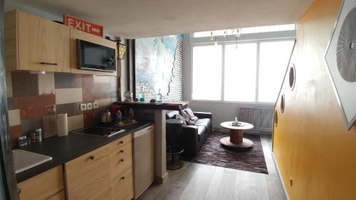 a small kitchen and living room with a couch at Joli LOFT en duplex , Art Déco , 2 pieces ,Centre Rouen - 130 in Rouen