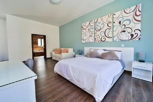 a bedroom with a large white bed and a couch at Il-Pipa in Għasri