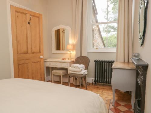 a bedroom with a bed and a desk and a mirror at Fox Cottage in Carnforth