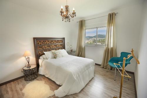 ビベイロにあるApartamento en Viveiroのベッドルーム(白いベッド1台、青い椅子付)