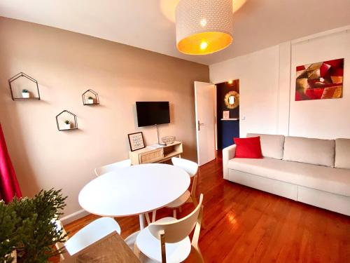 sala de estar con mesa blanca y sofá blanco en 7- Appartement pour 4 personnes entièrement refait à neuf en centre ville en Dieppe