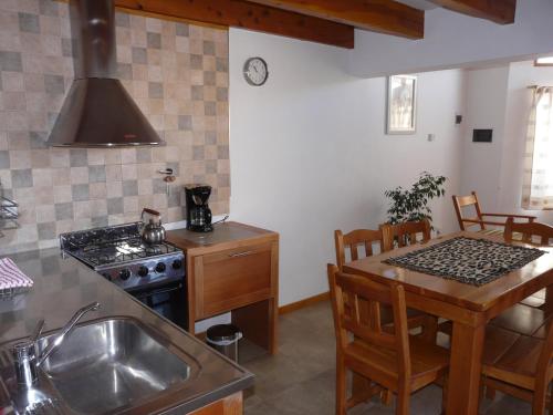 a kitchen with a sink and a stove at Del Sur Apart in Esquel