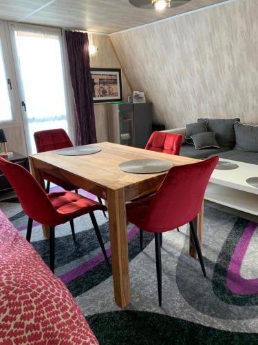 a room with a wooden table and red chairs at Siedlisko Kępina Zdrój in Ostrów