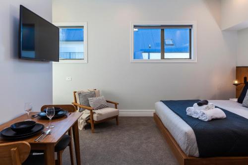 1 dormitorio con cama, mesa y TV en The Parque, en Christchurch