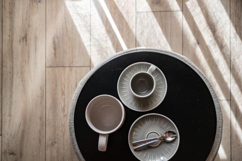 a black table with plates and a cup of coffee at Villa Jasmine in Bolzano