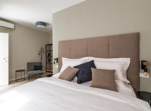 una camera da letto con un grande letto bianco con due cuscini di Villa Jasmine a Bolzano