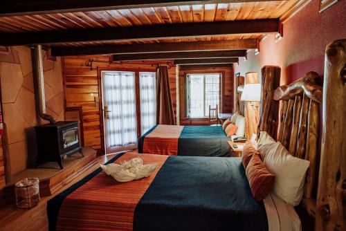 a hotel room with two beds and a television at The Lodge At Creel Eco - Hotel & Spa in Creel