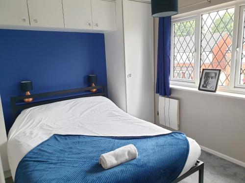 a blue bedroom with a bed with a towel on it at One Bedroom Apartment hosted Be More Homely Serviced Accommodation & Apartments Birmingham With X1 King Beds Sleeps 4 in Birmingham