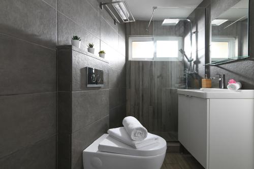 a bathroom with a white toilet and a sink at Stylish Apartment by City Center B in Heraklio