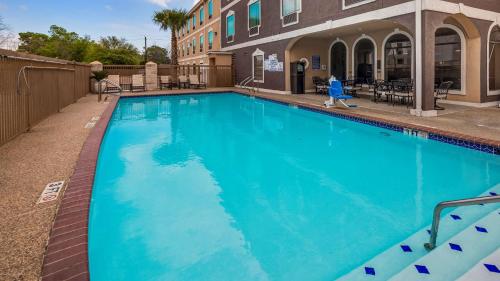 a large blue swimming pool in front of a building at Best Western Plus Heritage Inn Houston in Houston