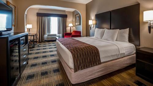 a hotel room with a bed and a television at Best Western Plus Heritage Inn in Houston