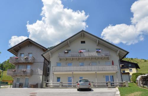 ein großes Gebäude mit einem davor geparkt in der Unterkunft Grimming Lodge Arnika in Tauplitz